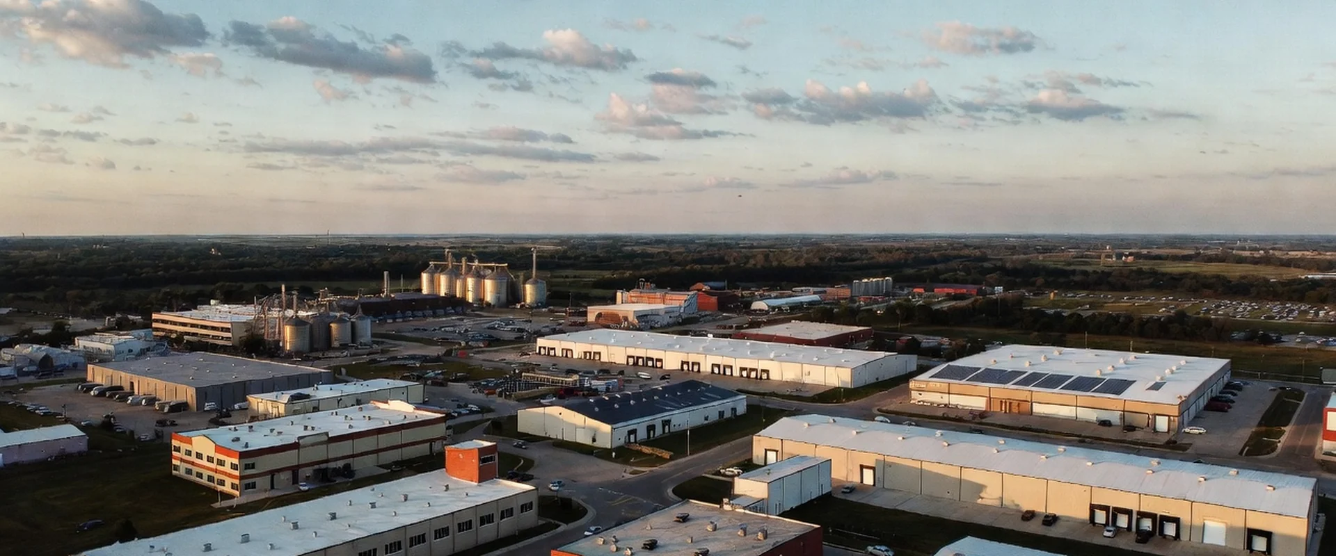 Panoramic aerial view of mixed industrial landscape with buildings, warehouses and silos